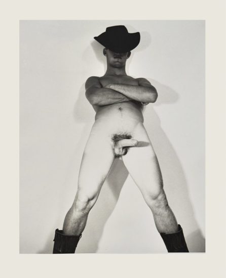 A black and white nude photograph of a man in a cowboy hat.