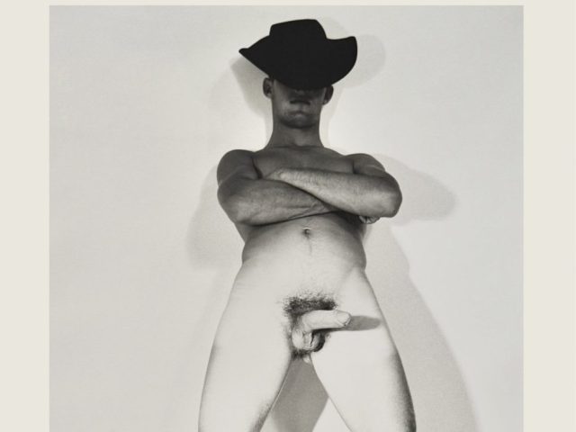 A black and white nude photograph of a man in a cowboy hat.
