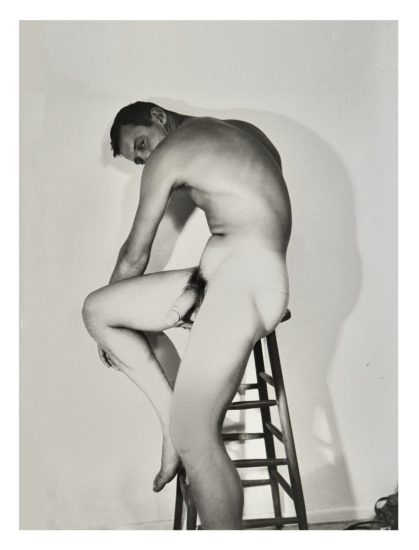 A black and white nude photograph of a man in a cowboy hat.