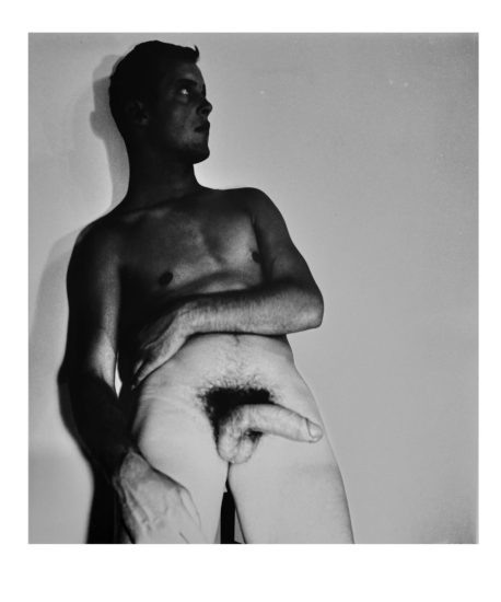 A black and white nude photograph of a man in a cowboy hat.