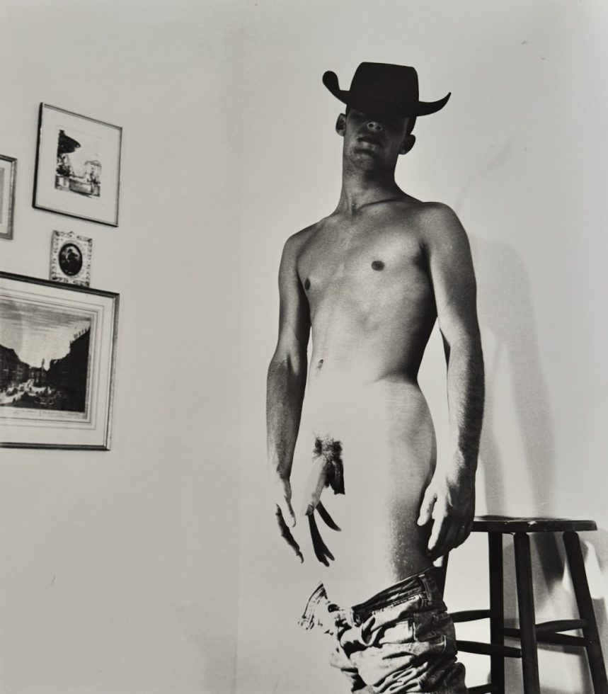 A black and white nude photograph of a man in a cowboy hat.