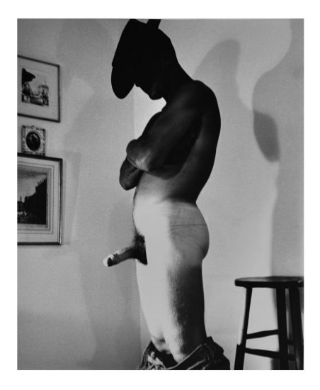 A black and white nude photograph of a man in a cowboy hat.
