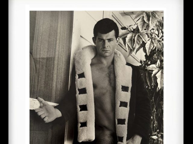 A black and white photograph of a partially nude man.