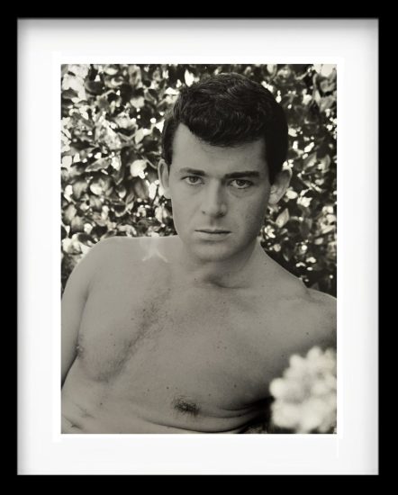 A black and white photograph of a shirtless man.