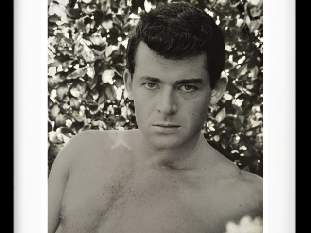 A black and white photograph of a shirtless man.