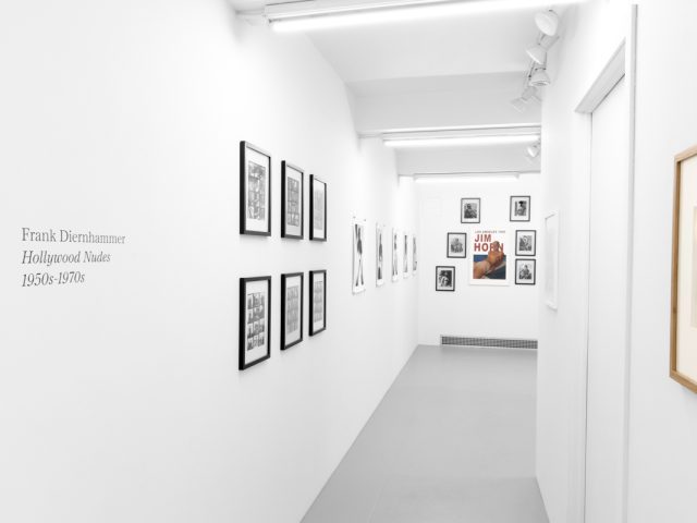 An installation photograph of black and white photography in a white-walled gallery space.