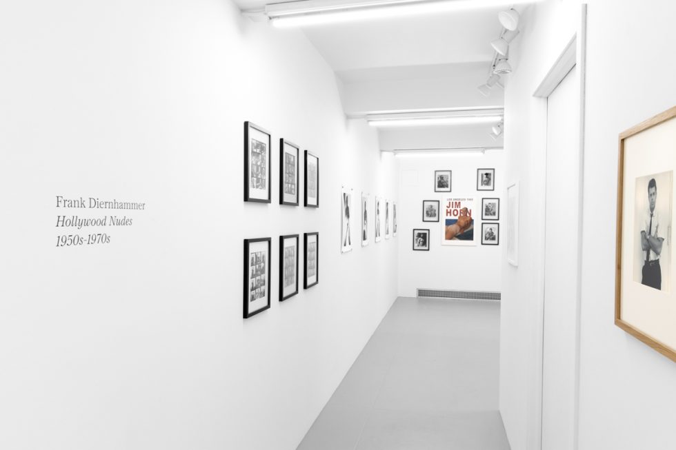 An installation photograph of black and white photography in a white-walled gallery space.
