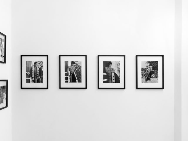 An installation photograph of black and white photography in a white-walled gallery space.