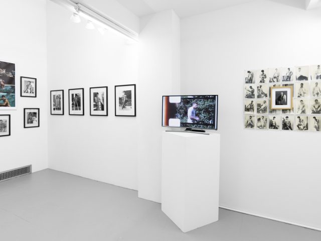 An installation photograph of black and white photography in a white-walled gallery space.