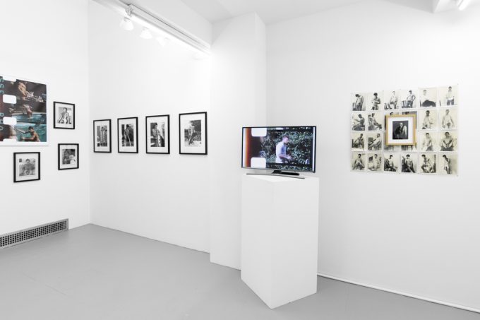 An installation photograph of black and white photography in a white-walled gallery space.