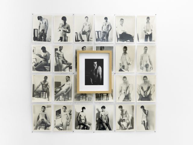 An installation photograph of black and white photography in a white-walled gallery space.