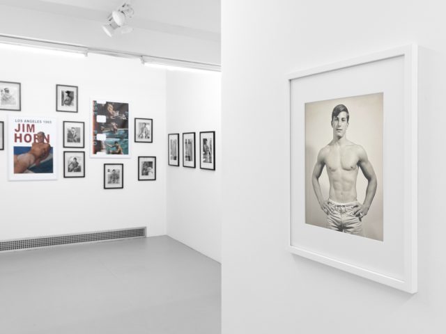 An installation photograph of black and white photography in a white-walled gallery space.