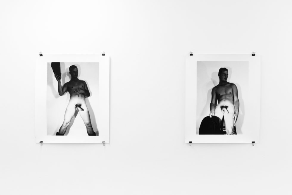 An installation photograph of black and white photography in a white-walled gallery space.