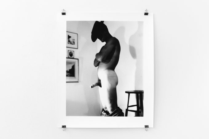 An installation photograph of black and white photography in a white-walled gallery space.