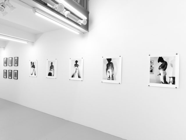 An installation photograph of black and white photography in a white-walled gallery space.