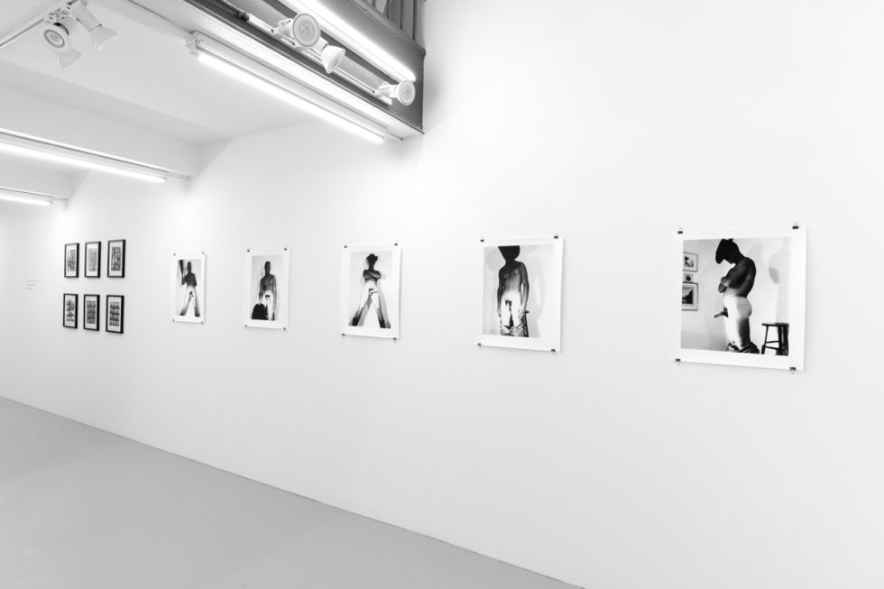 An installation photograph of black and white photography in a white-walled gallery space.