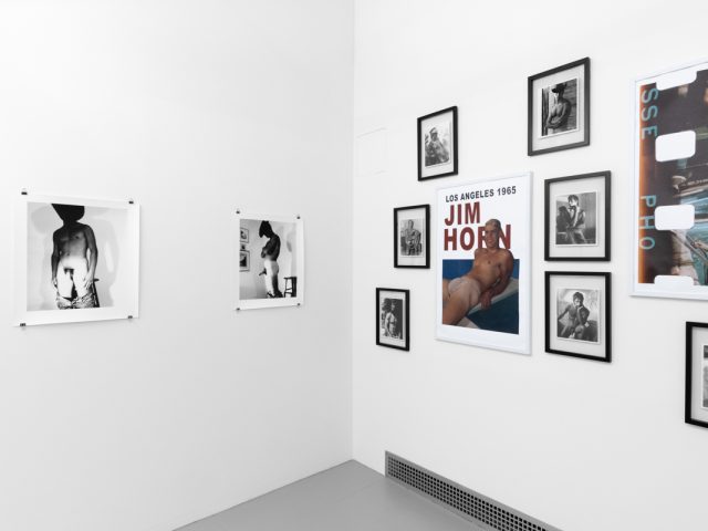 An installation photograph of black and white photography in a white-walled gallery space.
