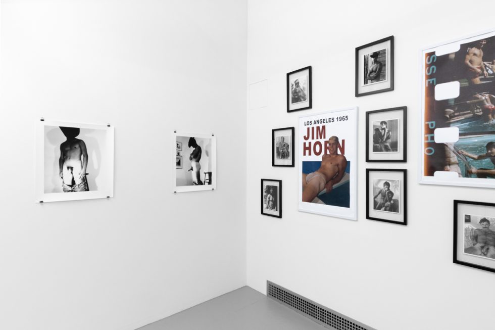 An installation photograph of black and white photography in a white-walled gallery space.
