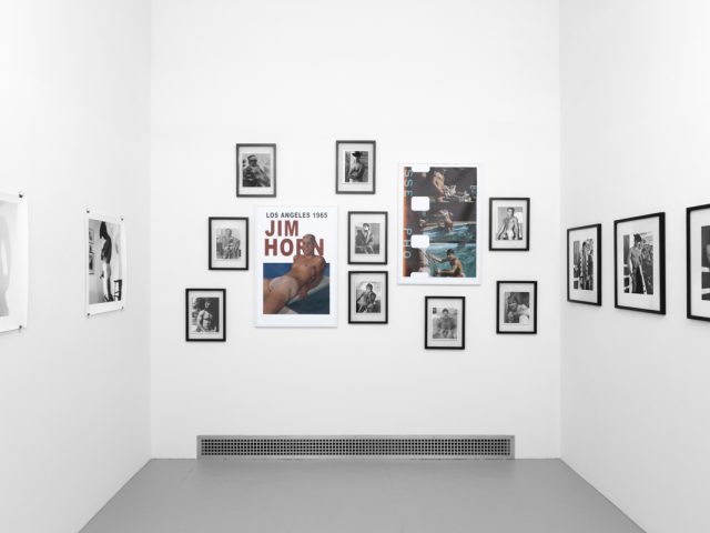 An installation photograph of black and white photography in a white-walled gallery space.