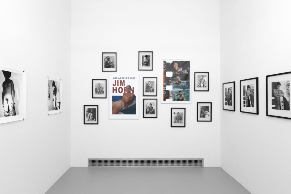 An installation photograph of black and white photography in a white-walled gallery space.