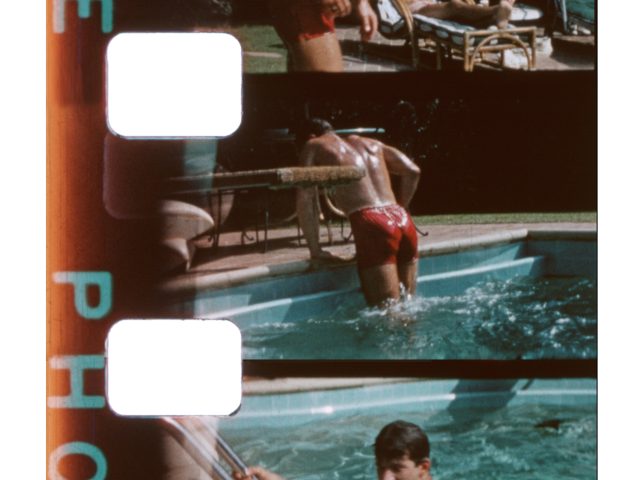 A scan of vintage color film of a shirtless man by a pool.