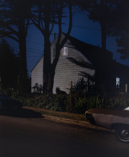 A photograph of a house lit by a streetlight at night.