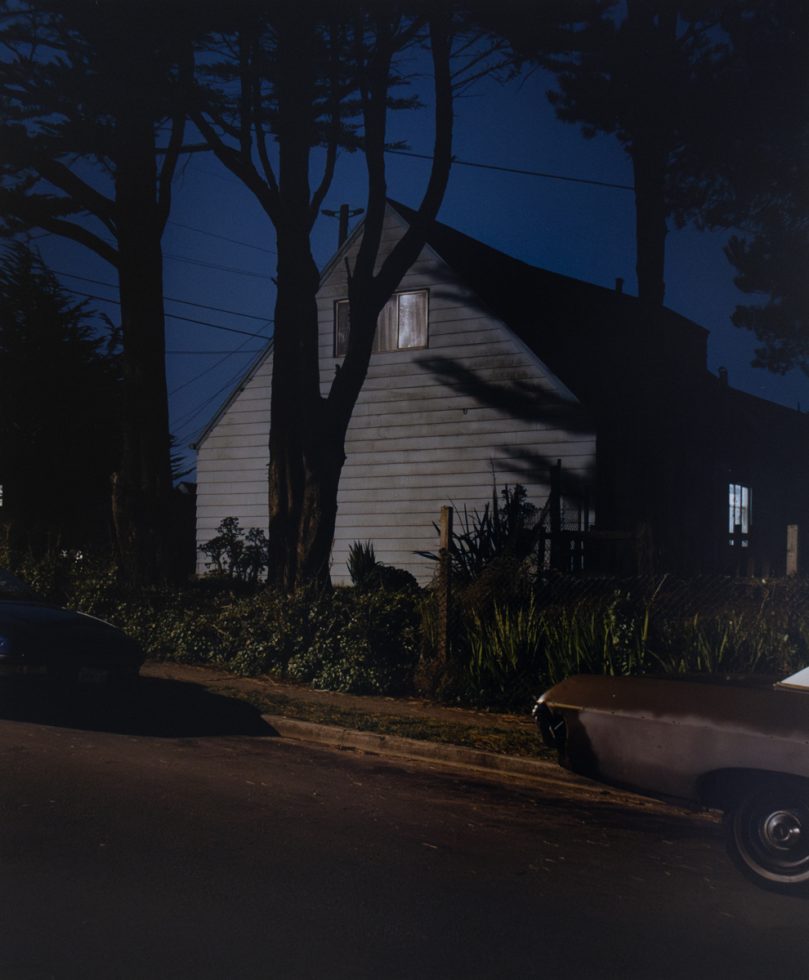 A photograph of a house lit by a streetlight at night.