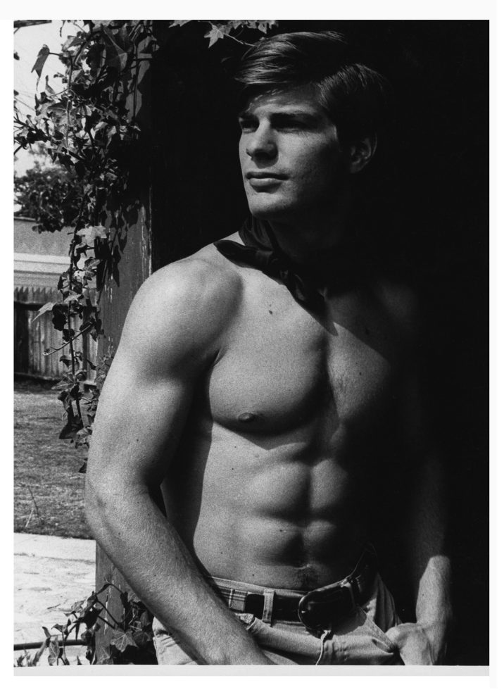 A black and white photograph of a handsome shirtless man.
