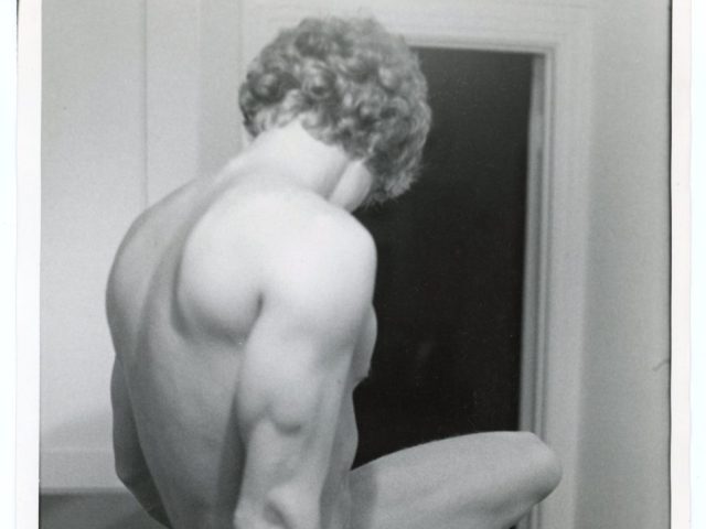 A black and white photograph of a nude man.