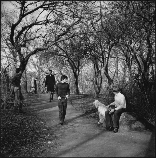 A black and white photograph of a man standing in a park.