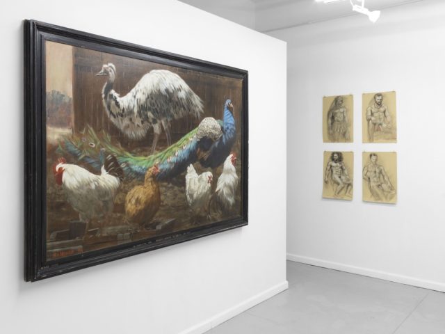 An installation photograph of various figurative artworks on a white gallery wall.