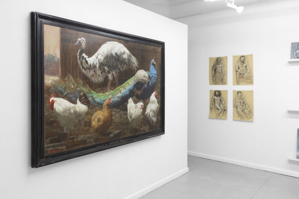 An installation photograph of various figurative artworks on a white gallery wall.