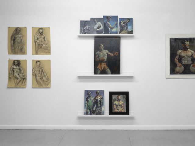 An installation photograph of various figurative artworks on a white gallery wall.