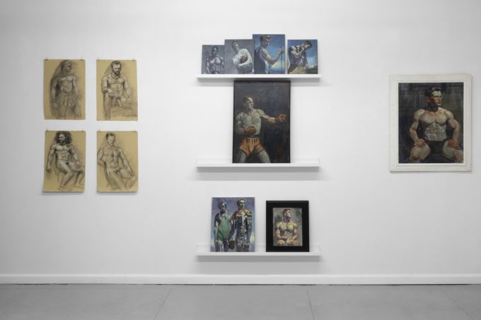 An installation photograph of various figurative artworks on a white gallery wall.