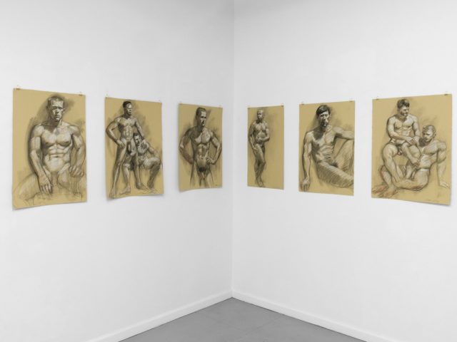 An installation photograph of various figurative artworks on a white gallery wall.