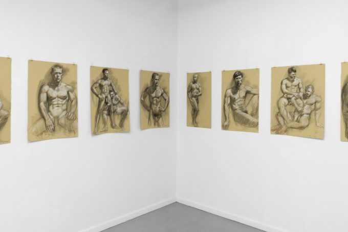 An installation photograph of various figurative artworks on a white gallery wall.