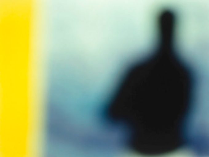 A soft focus image of a dark silhouette of a person against a blue backdrop, with a yellow band down the left side of the image.