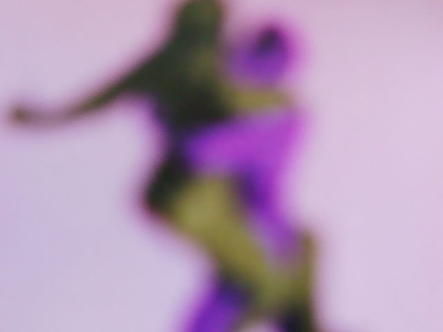 A purple-hued soft focus image of a couple embracing.