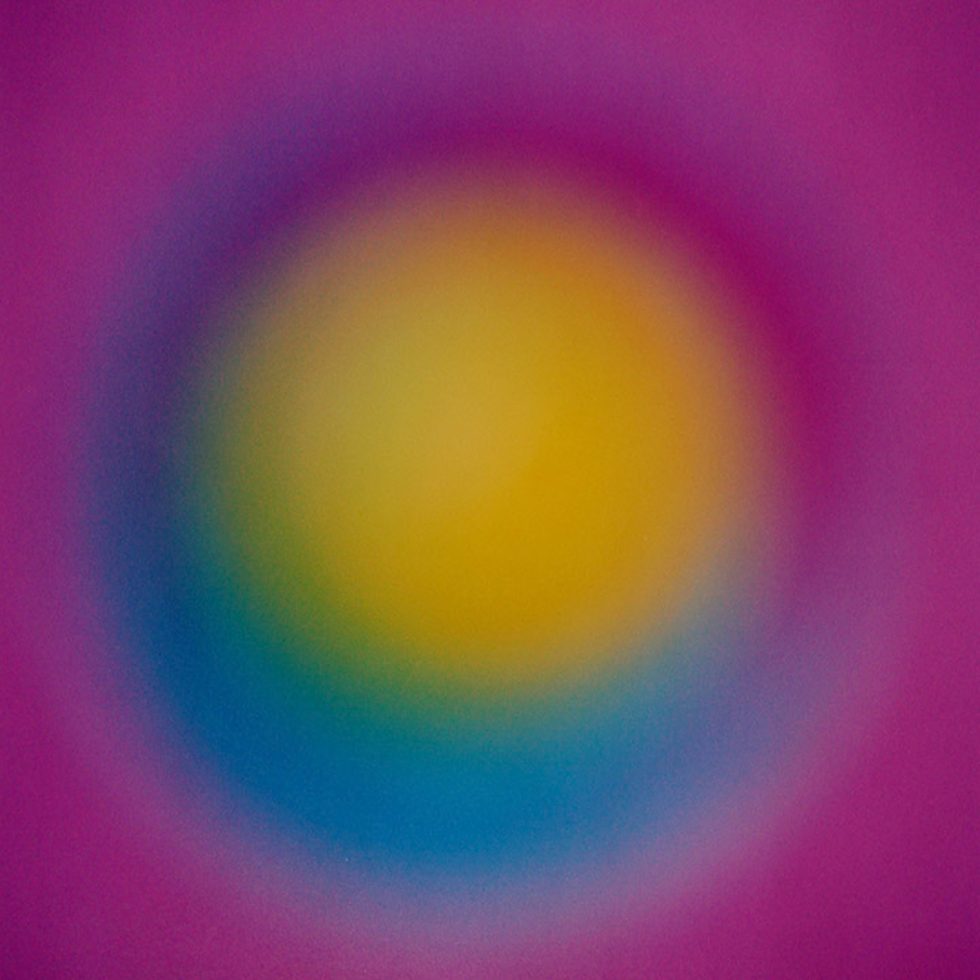 A colorful glowing orb of yellow with a blue perimeter and a purple background.