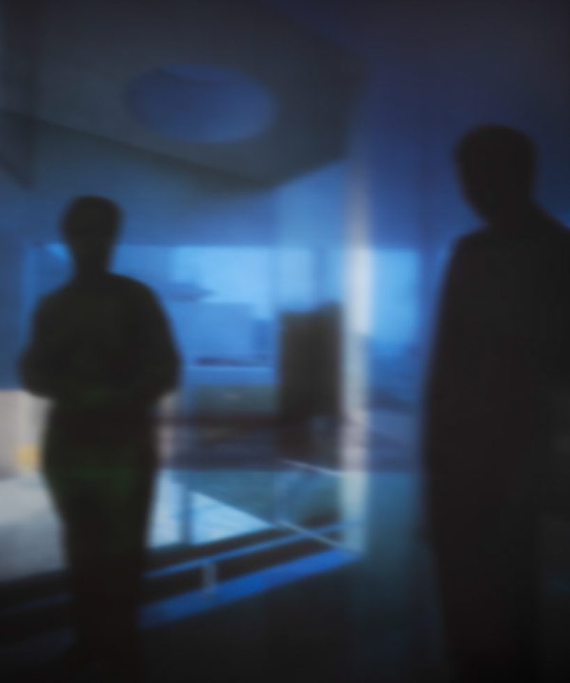 A soft focus image of two figures in blue surroundings.