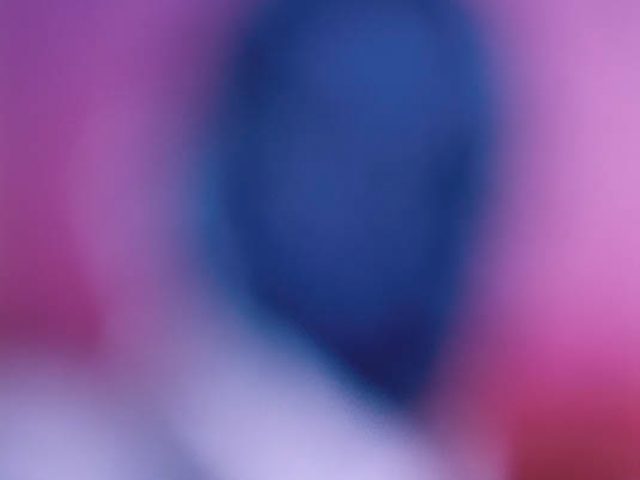 A colorful soft focus image of a figure rendered in purple and blue hues.