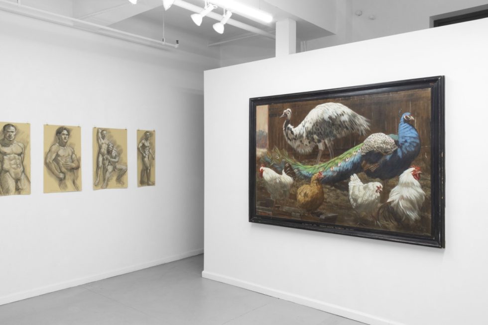 An installation photograph of various figurative artworks on a white gallery wall.