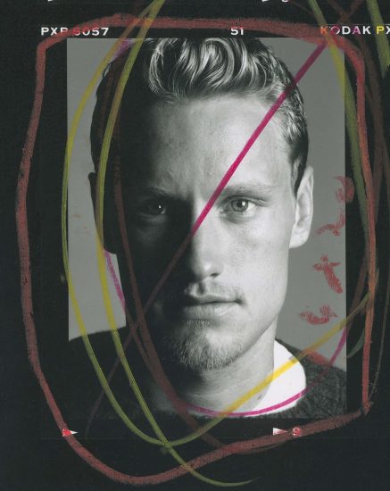 A black and white photograph of a man staring at the camera.