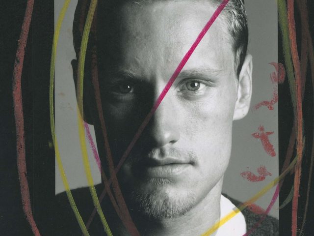 A black and white photograph of a man staring at the camera.