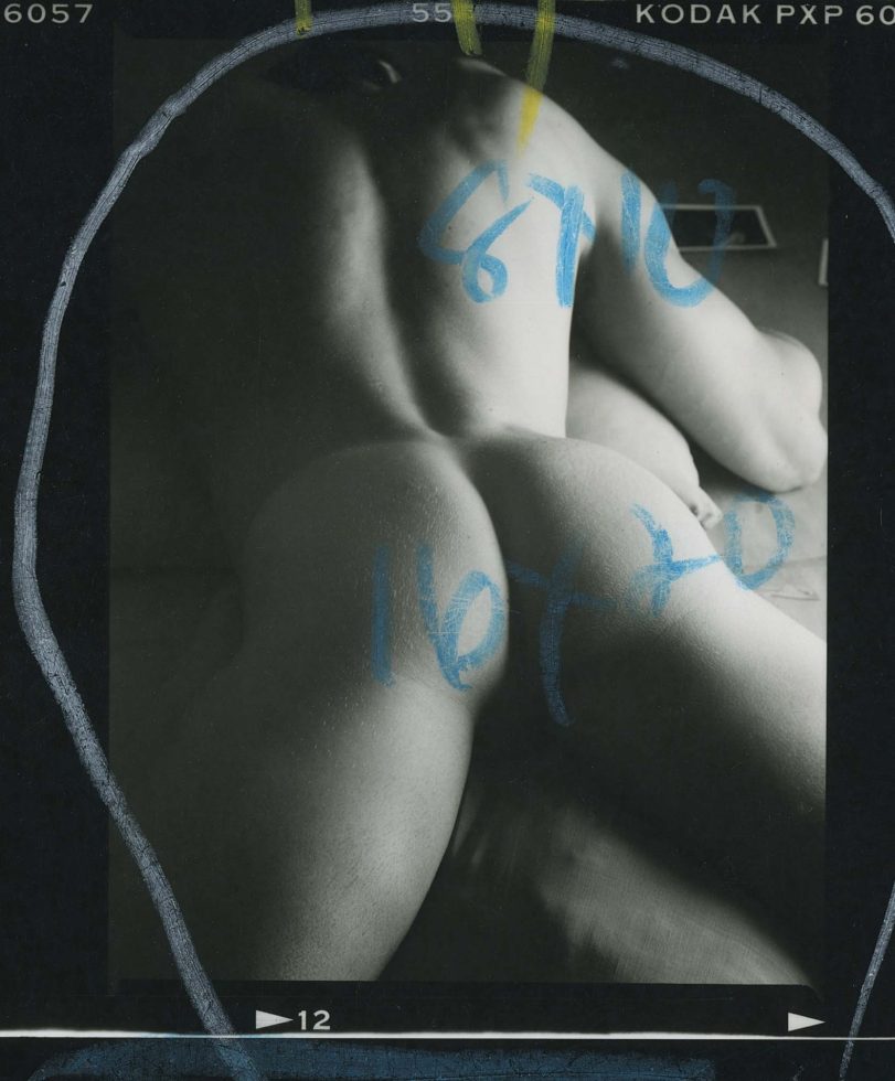 A black and white photograph of a nude man's behind.