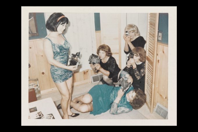 A group of women with cameras hanging out. 