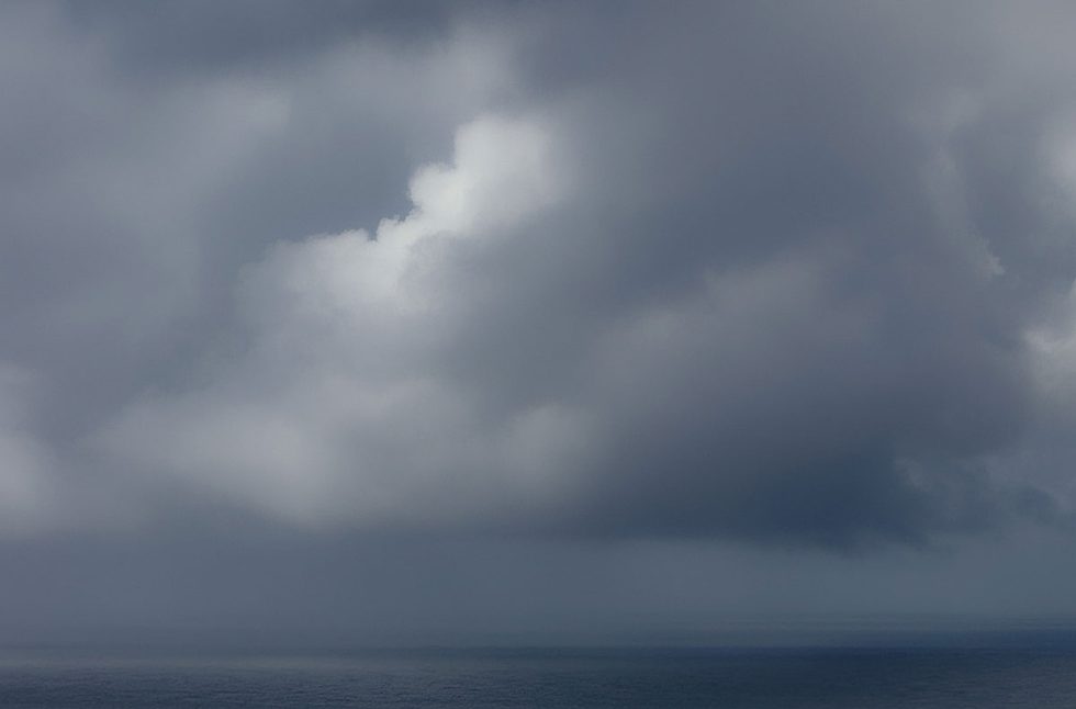 A photograph of a body of water with reflected light on the surface and a horizon line.