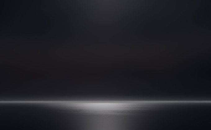 A photograph of a body of water with reflected light on the surface and a horizon line.