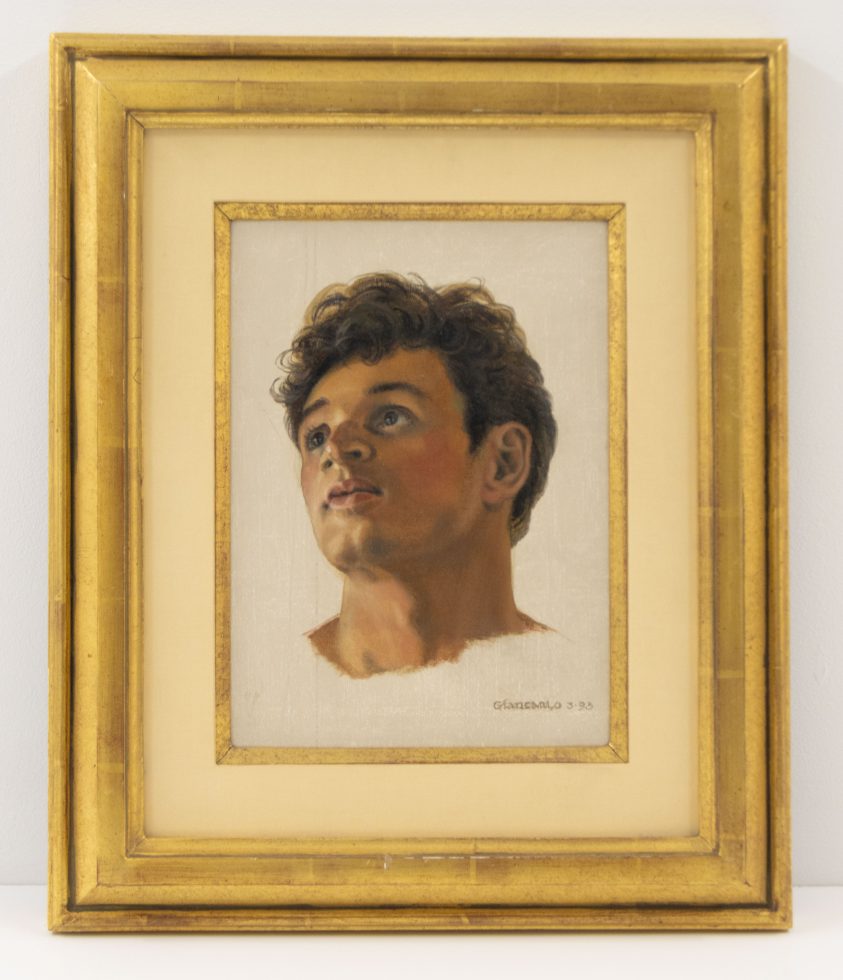 A small painting in a gilded frame of a young man with dark curly hair.