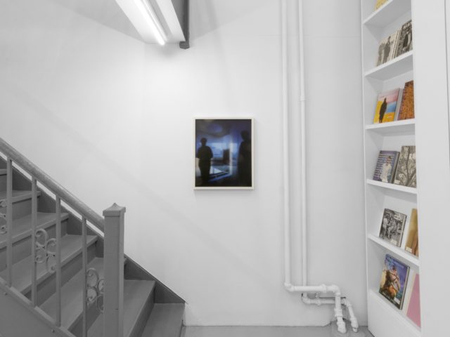 A photograph of an installation of colorful abstract works on a white gallery wall.